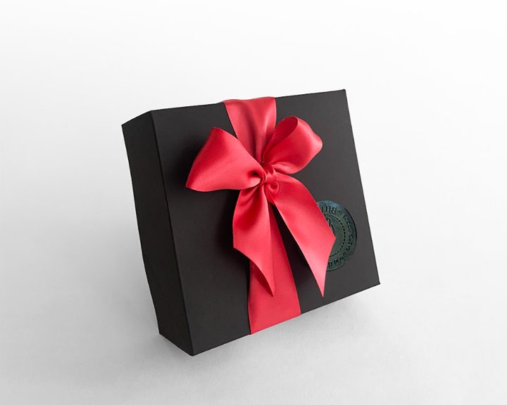 Black box with red ribbon for vegan gift basket idea.