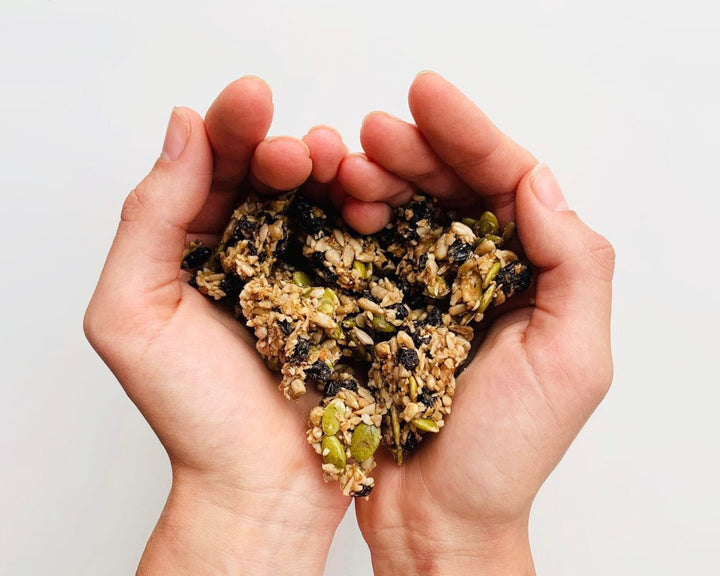 Image of loving hands holding granola made from sprouted nuts and sprouted seeds with organic superfoods.